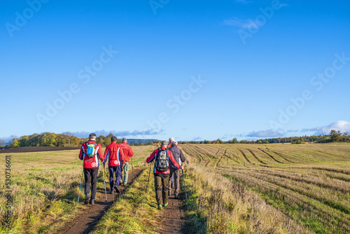 Men who walks on a dirt road along the fields