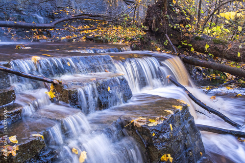 Running water in a small waterfall at autumn