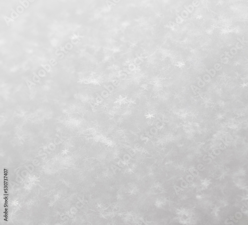 Small white snowflakes in winter as a background.