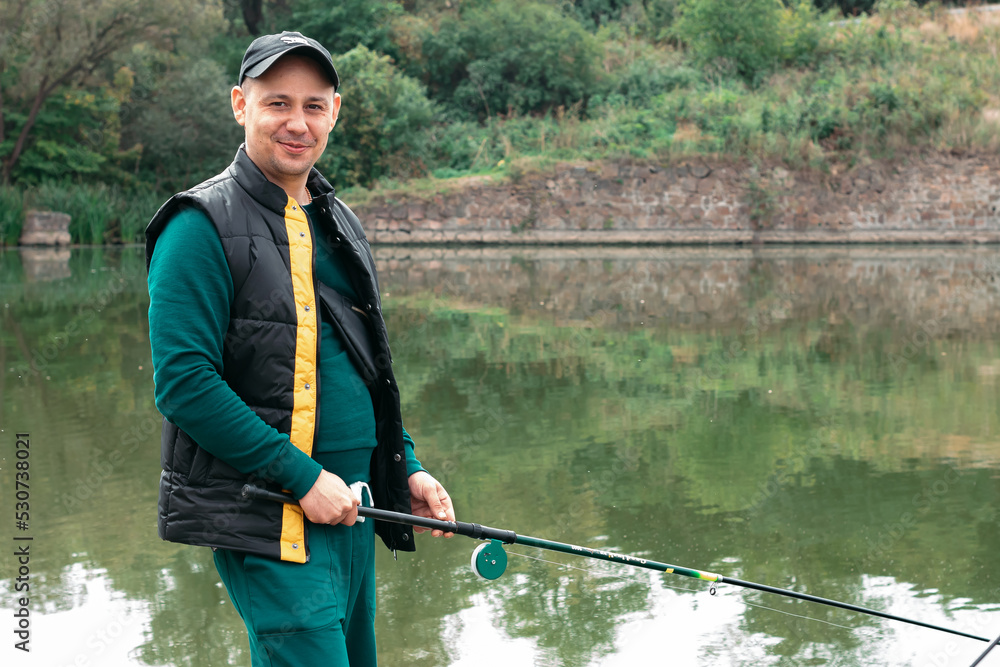 Man on a fishing rod in his hands catches fish on the river Man on a fishing rod in his hands catches fish on the river