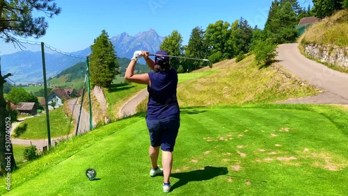 Golfer Teeing Off with Mountain View in a Sunny Summer Day in Burgenstock, Nidwalden, Switzerland.