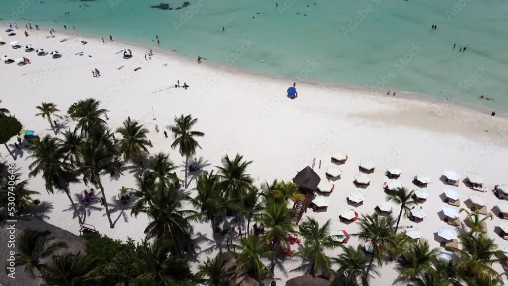 Aerial drone shot over tourists sunbathing along a sandy beach on North Beach Isla Mujeres island in Quintana Roo, Mexico. Aerial drone shot over tourists sunbathing along a sandy beach on North Beach Isla Mujeres island in Quintana Roo, Mexico.