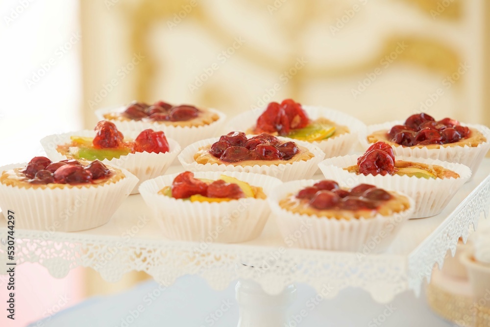 Beautiful and bright desserts on the festive table for the party. Confectionery with cream and marzipan. Beautiful and bright desserts on the festive table for the party. Confectionery with cream and marzipan.