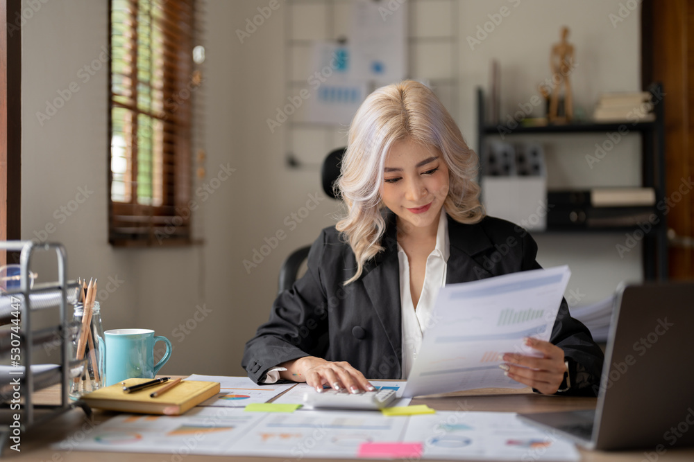 Happy smiling young asian entrepreneur woman counting profit, on calculator at laptop computer, analyzing benefits, enjoying financial success, job high result.