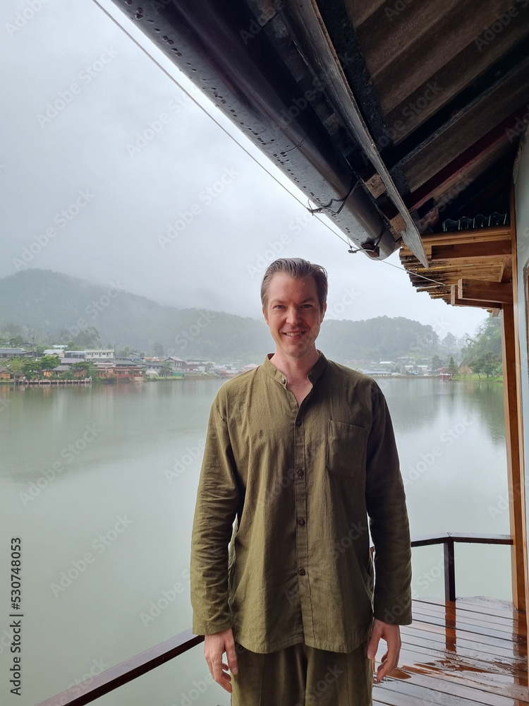 Happy tourist man wearing traditional clothes in Ban Rak Thai, a Chinese settlement in Mae Hong Son, Thailand Happy tourist man wearing traditional clothes in Ban Rak Thai, a Chinese settlement in Mae Hong Son, Thailand