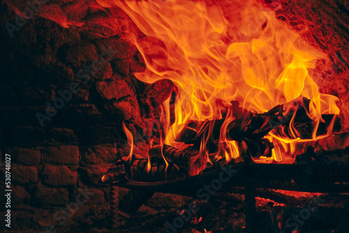 Wood fire in yellow and red colors burning in stone oven, copy space.