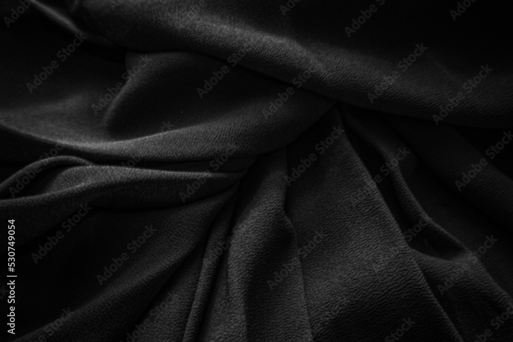 Fototapeta premium Black pleated fabric. Dark clothes background.