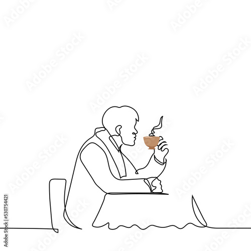 man in a coat and scarf sits at a table in a street cafe (terrace) with a steaming cup of hot tea - one line drawing vector. concept keep warm in autumn or winter with hot drinks