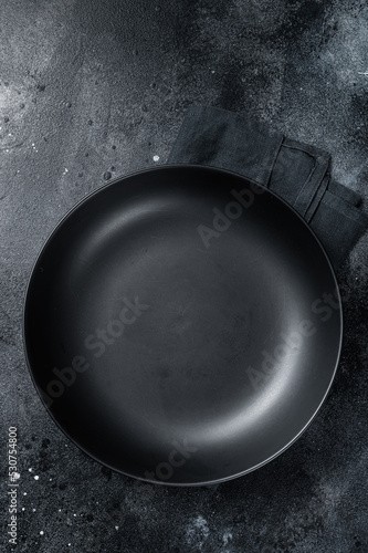 Empty black craft plate on table. Table setting. Black background. Top view. Copy space