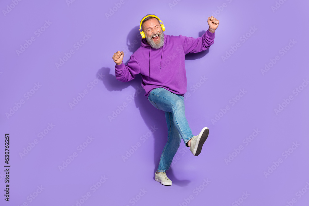 Portrait of retired funny carefree man dressed purple hoodie headphones dancing listen best songs isolated on violet color background
