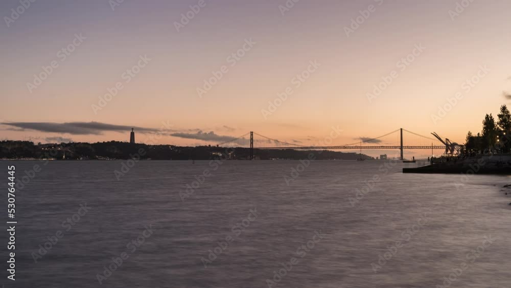 timelapse day to night and sunset of the Tajo river, 25th of April bridge and National Sanctuary of Christ the King, lisbon, Portugal timelapse day to night and sunset of the Tajo river, 25th of April bridge and National Sanctuary of Christ the King, lisbon, Portugal