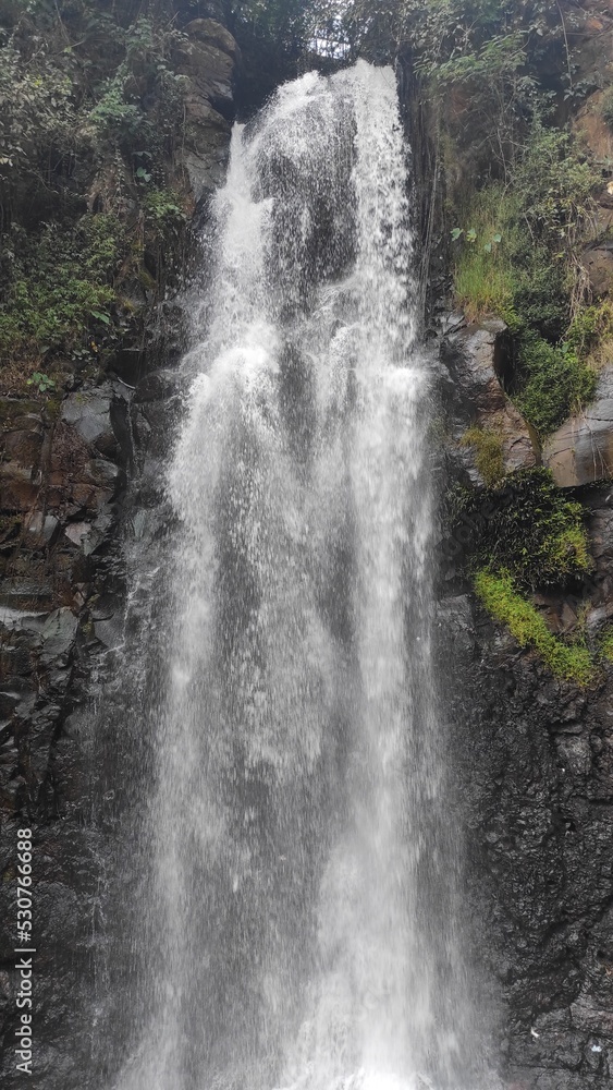 Obraz premium Abstract Defocused Blurred Background photo of scenery of waterfalls and mossy cliffs, one of the popular tourist destinations in the Cicalengka area - Indonesia. Not Focus