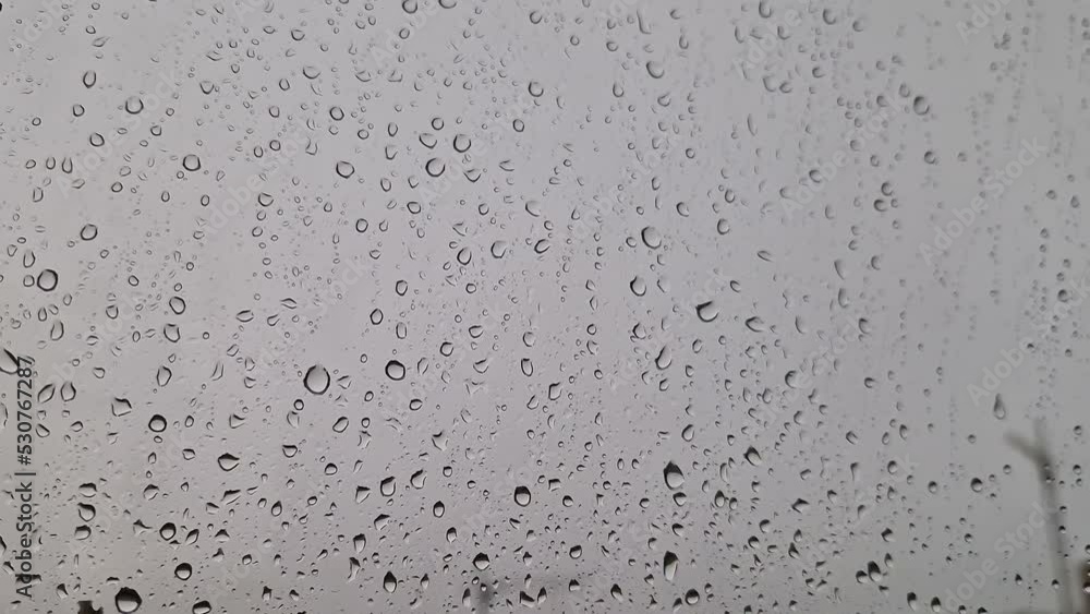 Close-up of water droplets on glass during a summer downpour. Close-up of water droplets on glass during a summer downpour.