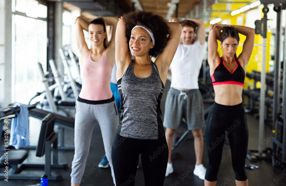 Fitness, sport, people and lifestyle concept. Group of smiling people exercising together in gym Fitness, sport, people and lifestyle concept. Group of smiling people exercising together in gym