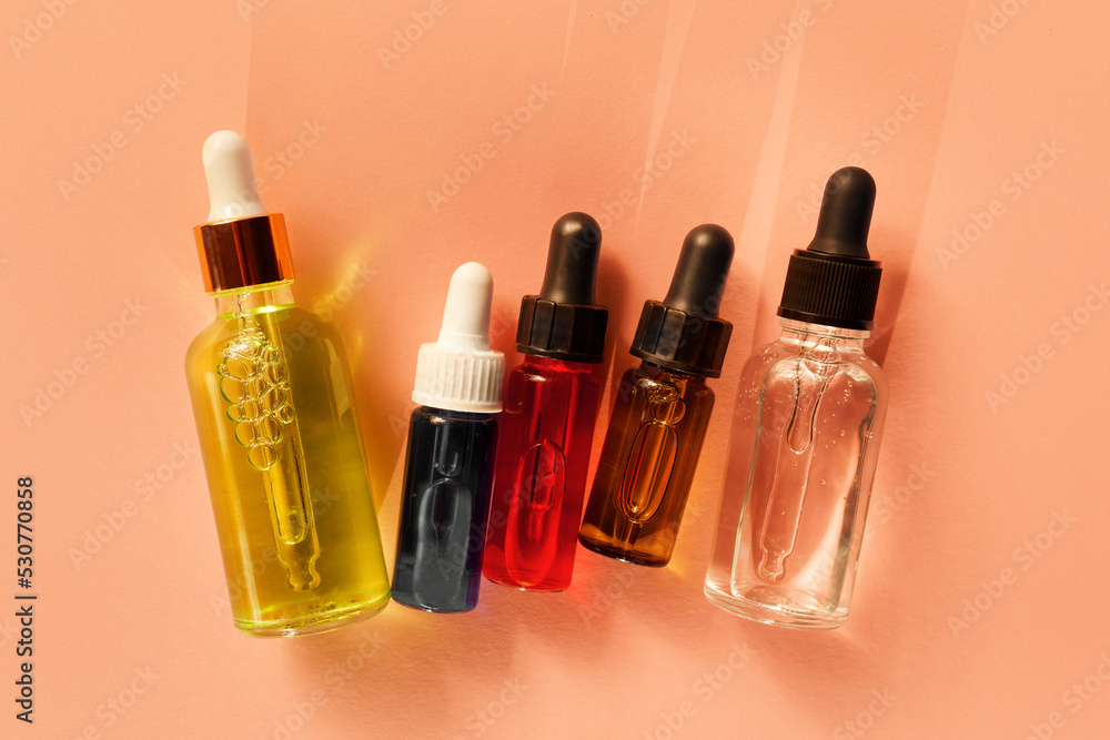 Five different glass dropper bottles with serum, oil, gel and beauty products on beige background. Pipette with fluid hyaluronic acid, retinol, vitamin c and a. Natural cosmetics, healthcare, bodycare Five different glass dropper bottles with serum, oil, gel and beauty products on beige background. Pipette with fluid hyaluronic acid, retinol, vitamin c and a. Natural cosmetics, healthcare, bodycare