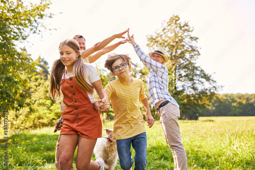 Fototapeta premium Eltern und zwei Kinder machen zusammen ein Spiel a