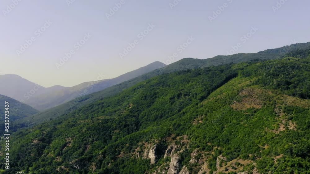 Aerial view over green old mountains on bright clear summer sky. Aerial view over green old mountains on bright clear summer sky.