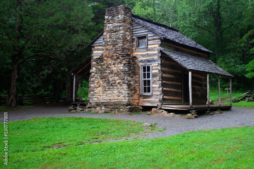 Bild auf Leinwand Old log cabin in the forest on a wet rainy day.