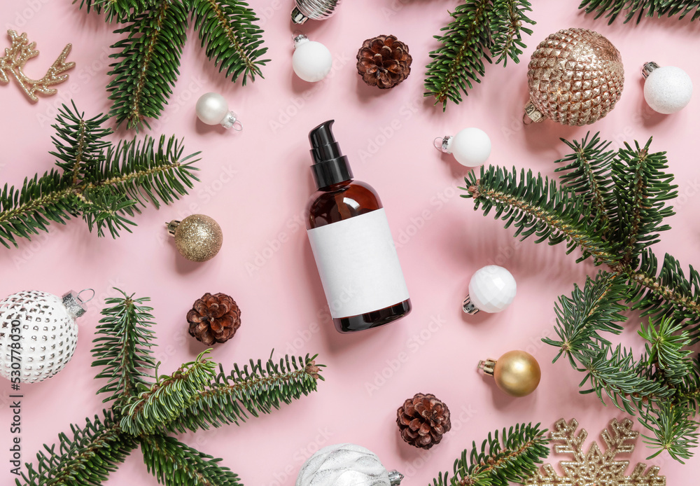 Cosmetic one pump Bottle near Christmas decorations, fir branches and pine cones on pink, mockup Cosmetic one pump Bottle near Christmas decorations, fir branches and pine cones on pink, mockup