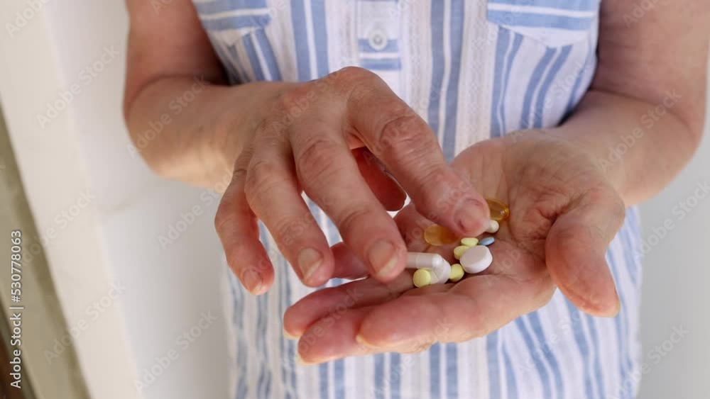 In the hands of an elderly woman, a handful of pills and vitamins, she chooses In the hands of an elderly woman, a handful of pills and vitamins, she chooses