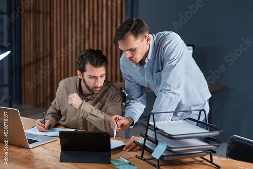 young businessmen working in the office together at night .