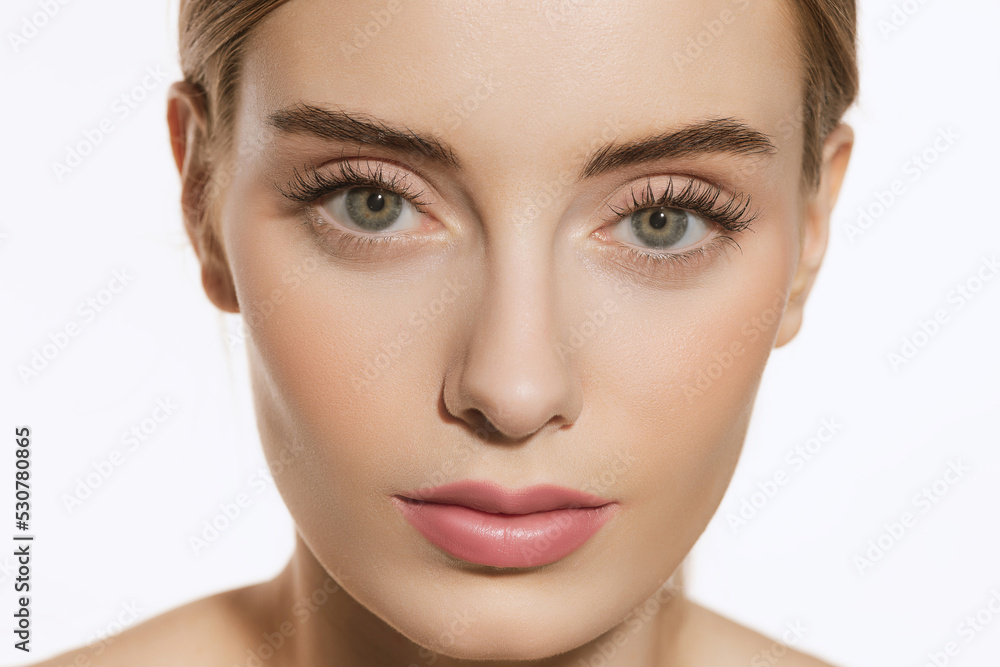 Portrait of young female fashion model with nude makeup isolated on white studio background. Spa, surgery, face lifting and skin care concept Portrait of young female fashion model with nude makeup isolated on white studio background. Spa, surgery, face lifting and skin care concept
