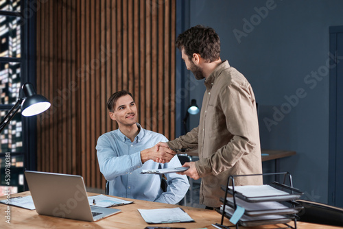 business colleagues shaking hands at the workplace. photo