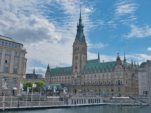 The Hamburg City Hall with the river and flags in the foreground
