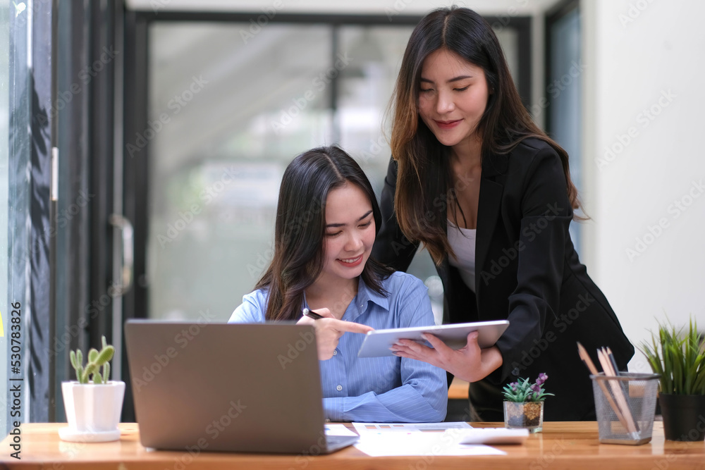 Two Young Asian businesswoman discuss with new startup project Idea presentation, analyze planning and financial statistics and investment market at office. Two Young Asian businesswoman discuss with new startup project Idea presentation, analyze planning and financial statistics and investment market at office.