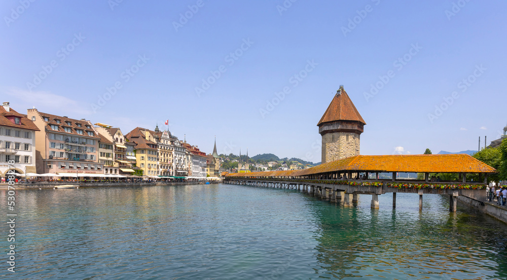LUCERNE, SWITZERLAND, JUNE 21, 2022 - View of the wodden covered Kapellbrücke Bridge on the Reuss river in Lucerne, Switzerland