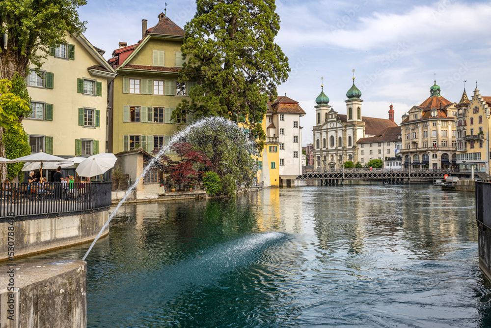 LUCERNE, SWITZERLAND, JUNE 21, 2022 - View of the Jesuit church of St. Franz Xaver on the Reuss river in Lucerne, Switzerland