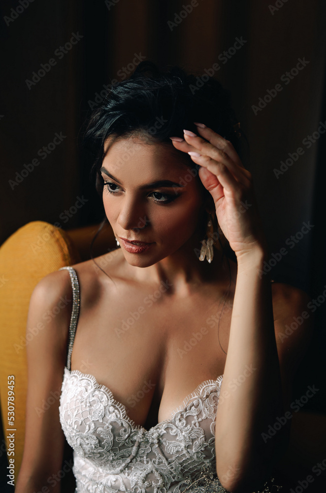 Brunette girl bride on a yellow armchair with a bouquet. Stylish wedding look at the hotel. Brunette girl bride on a yellow armchair with a bouquet. Stylish wedding look at the hotel.