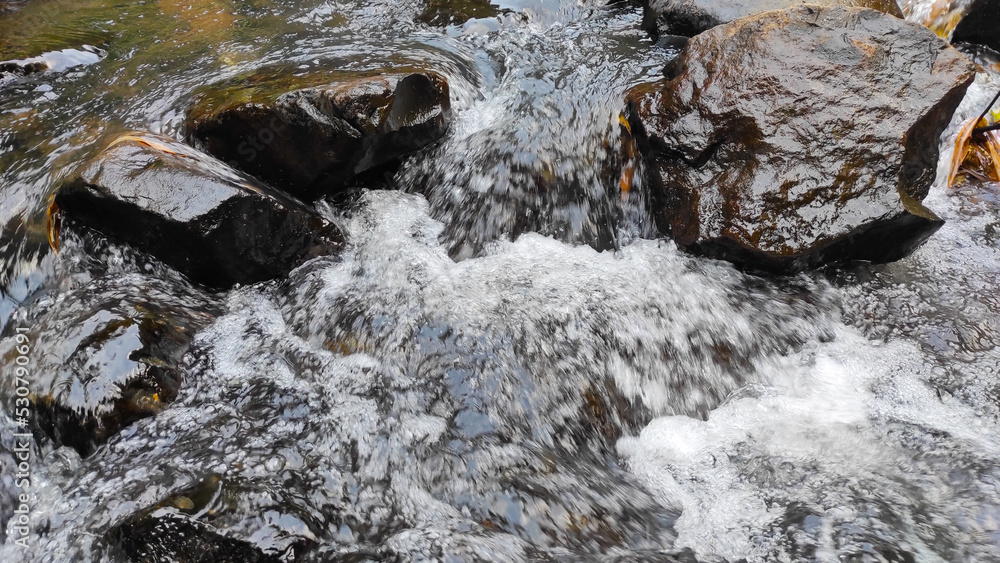 Fototapeta premium Abstract Defocused Blurred Photo of water ripples on the rocks in the river in the Cicalengka Tourism area - Indonesia. Not Focus