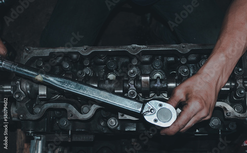 The mechanic is checking the engine.