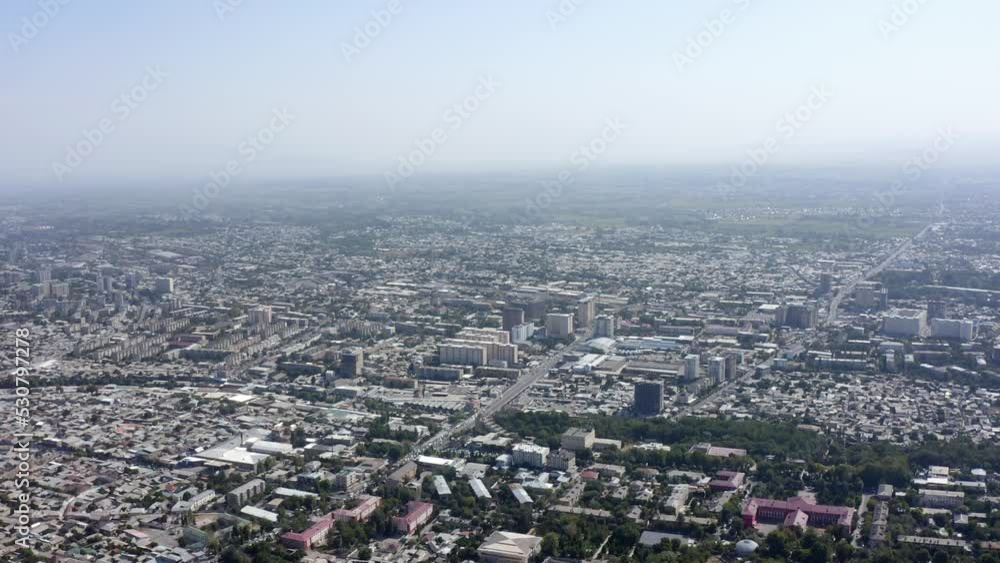 Panorama of the city of Osh from a bird's-eye view. View of the roofs of houses, roads, parks and the amazing nature of Kyrgyzstan. Panorama of the city of Osh from a bird's-eye view. View of the roofs of houses, roads, parks and the amazing nature of Kyrgyzstan.