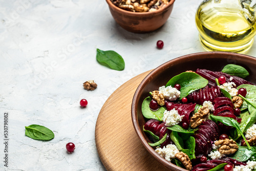 Fototapeta Naklejka Na Ścianę i Meble -  Healthy Beet Salad with fresh sweet baby spinach, cheese, nuts, cranberries on a dark background. place for text, top view