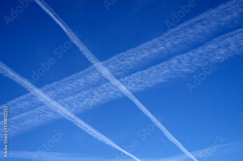 Mehrere Kondesstreifen im Muster am blauen Himmel wie Wolken photo