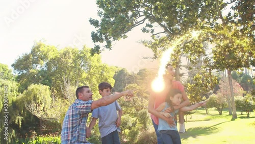 Animation of light spots over caucasian family spending time in park together