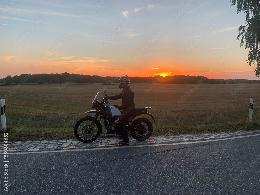 Obraz premium Motorradfahrer im Sonnenuntergang 