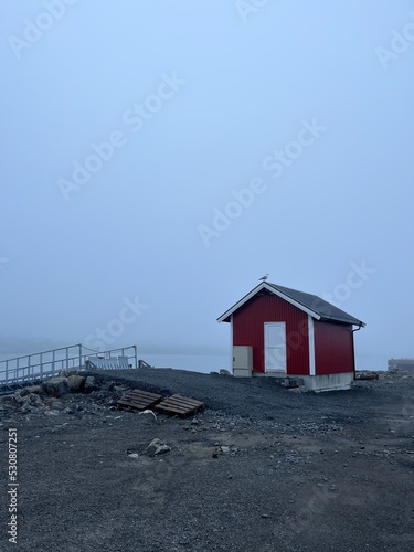 Small fishing house in the fog by the sea