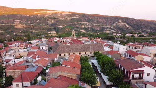 Aerial drone footage of traditional countryside village Omodos, Limassol, Cyprus. Establish scene of Timios Stavros (Holy Cross) monastery, tiled roof houses and balconies, narrow streets from above. photo