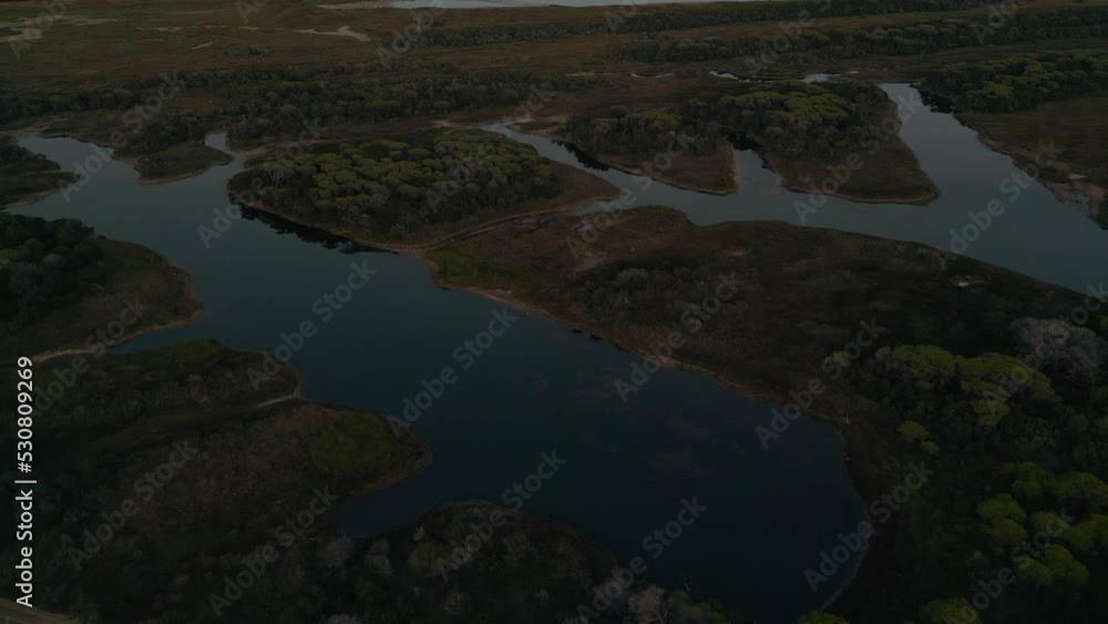 Sunset at Maremma National Park with panoramic evening sky in Tuscany, Italy. Cinematic aerial drone footage of the savannah swamp, seaside coast and pine tree forest with an island in the distance. Sunset at Maremma National Park with panoramic evening sky in Tuscany, Italy. Cinematic aerial drone footage of the savannah swamp, seaside coast and pine tree forest with an island in the distance.