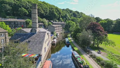 Aerial video footage of Hebden Bridge a lovely old textile mill town on the Rochdale Canal in West Yorkshire England. Showing Locks, Canal Boats, Barges, and old world houses. photo