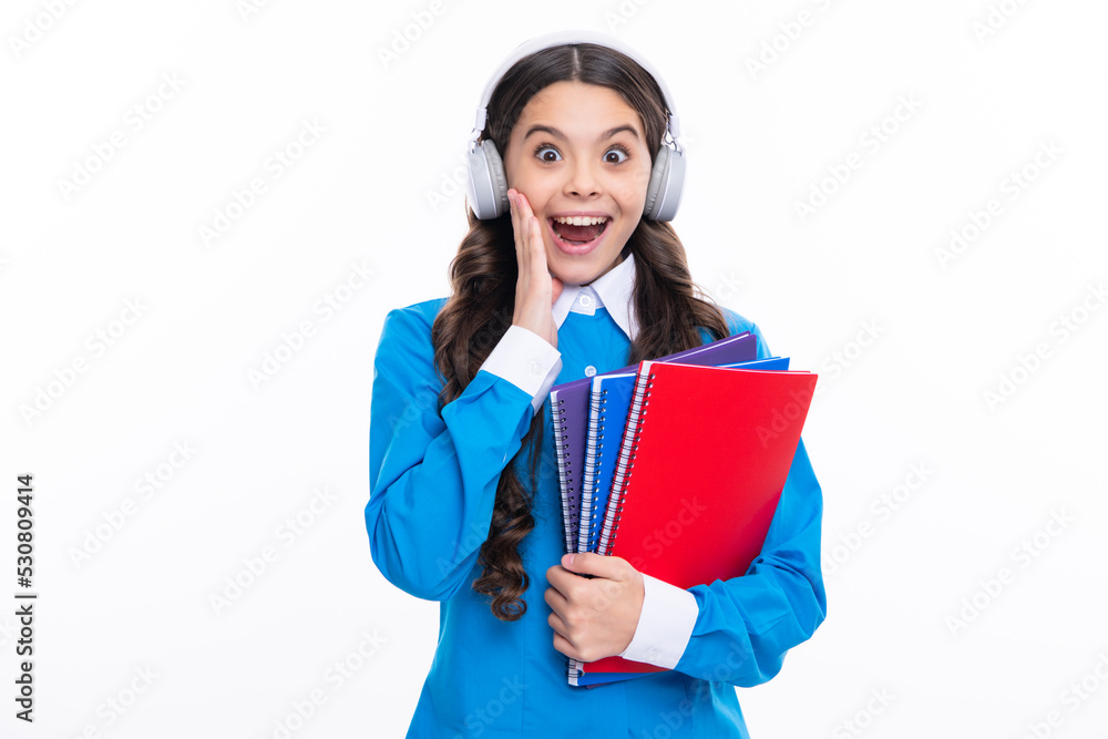 Excited face. School child girl with headphones and book isoalted on white background. Amazed expression, cheerful and glad. Excited face. School child girl with headphones and book isoalted on white background. Amazed expression, cheerful and glad.
