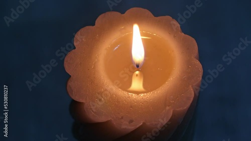 a burning candle on a blue background in the center