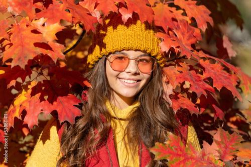 Teen child girl on autumn fall leaves background. smiling girl in sunglasses at autumn leaves on natural background