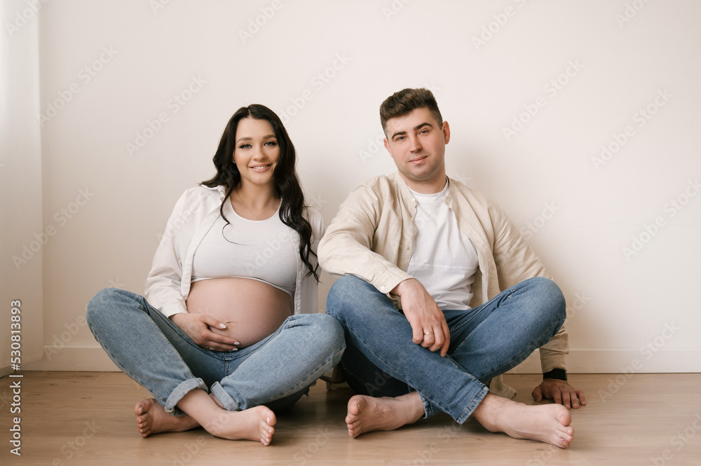 Young pregnant woman with husband at home, happy family and pregnancy concept Young pregnant woman with husband at home, happy family and pregnancy concept