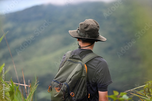 Asian hiking man look view beautiful rainforest mountain landscape, Adventure and trekking concept.