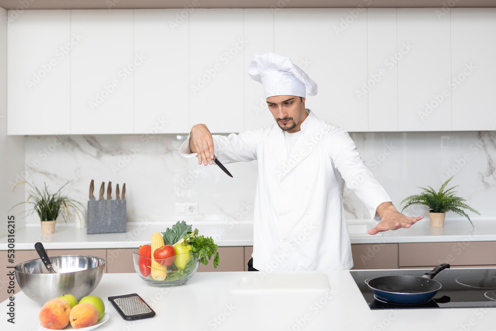 Young handsome male chef in cooking in the kitchen Young handsome male chef in cooking in the kitchen