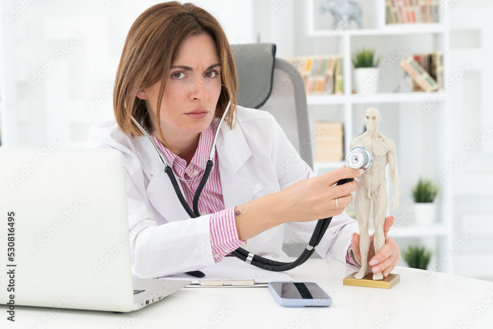 Young beautiful female doctor checking up with stethoscope a human model mock up in office of the clinic
Young beautiful female doctor checking up with stethoscope a human model mock up in office of the clinic